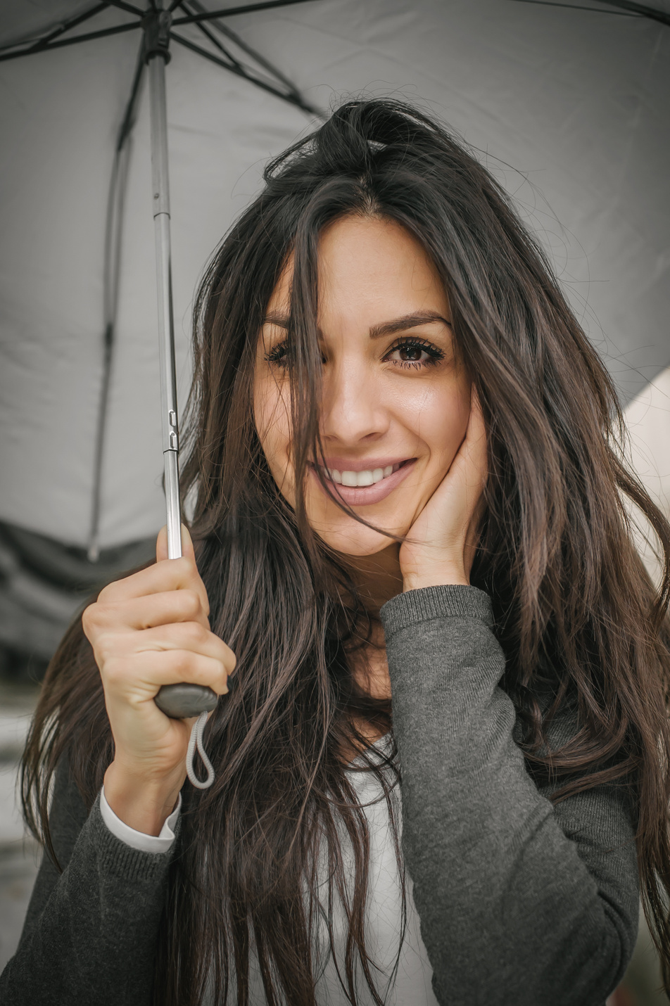 Happy smiling woman under umbrella in rain